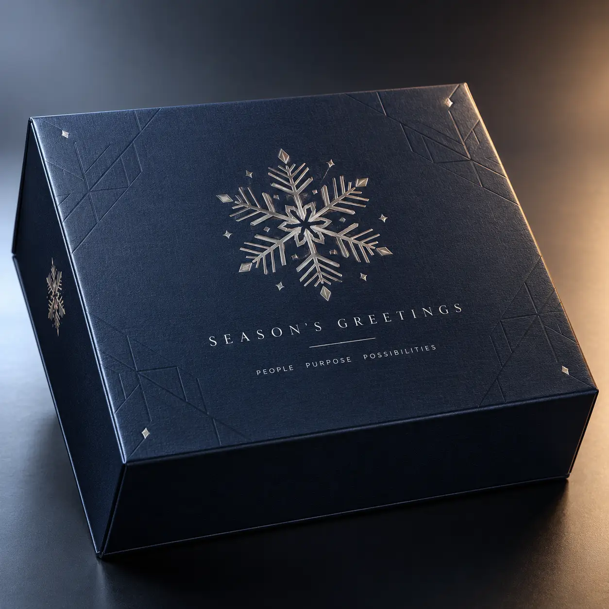 Luxury navy blue corporate Christmas gift box with silver foil snowflake and Season's Greetings embossed text, elegant holiday packaging