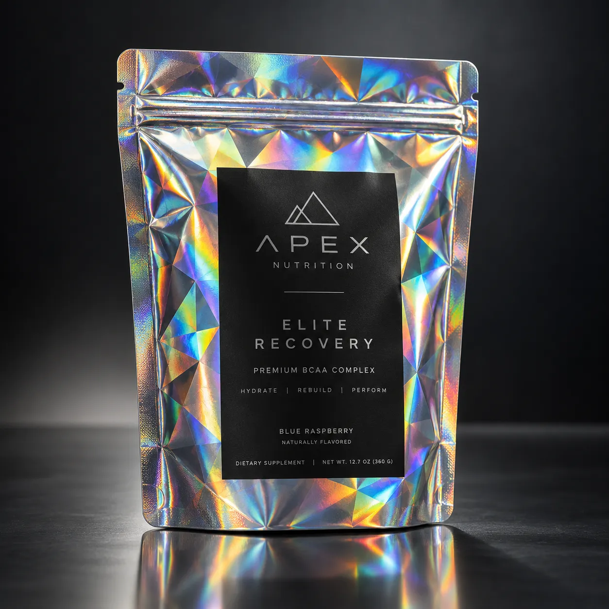 Holographic silver BCAA supplement pouch by Apex Nutrition, Elite Recovery blue raspberry flavor, 360g, reflective studio shot